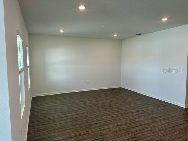 4734 Southwest 83rd Loop Ocala, FL 34476 - Photo 7 of 28 an empty room with wooden floor and a window