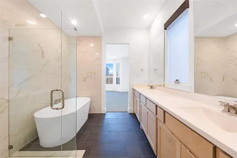 a bathroom with a double vanity sink a mirror and a bathtub