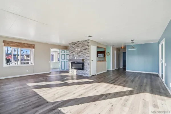 an empty room with fireplace and windows