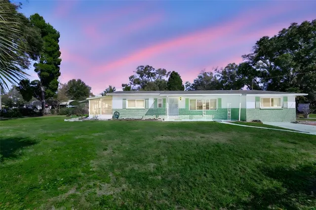 a front view of a house with a garden and yard