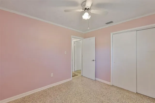 an empty room with a ceiling fan and a fan