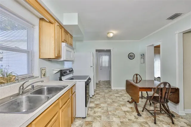 a kitchen that has a sink and chairs in it