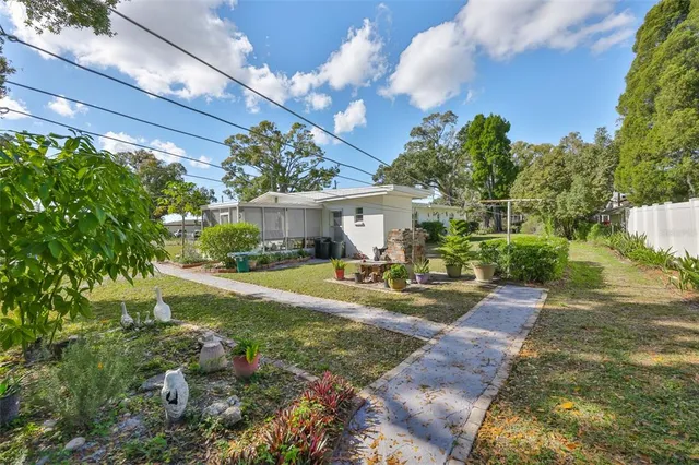 a view of a house with backyard and sitting area