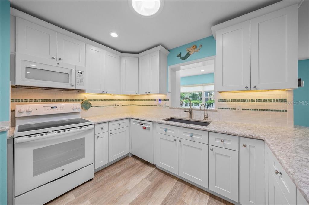 8720 Southwest 90th Street, Unit A Ocala, FL 34481 - Photo 27 of 71 a kitchen with granite countertop white cabinets and white appliances