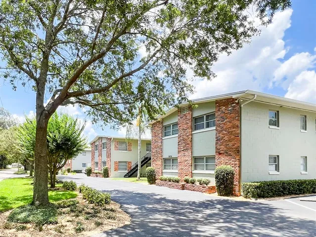a front view of a house with a yard and trees