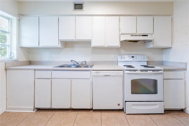 a kitchen with white cabinets and white appliances