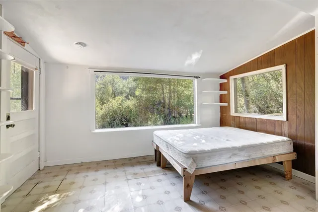 a bed sitting in a room next to a window