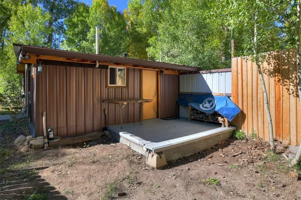 a view of backyard with small cabin and wooden fence