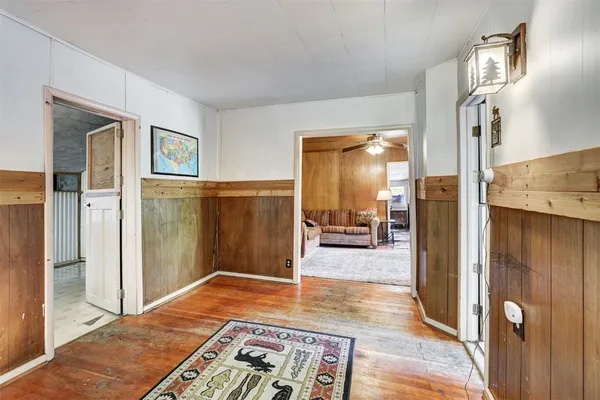 a view of a hallway with wooden floor windows and a livingroom