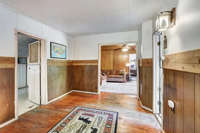 a view of a hallway with wooden floor windows and a livingroom