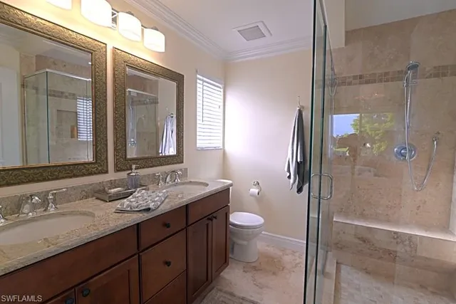 a bathroom with a granite countertop sink toilet mirror and shower