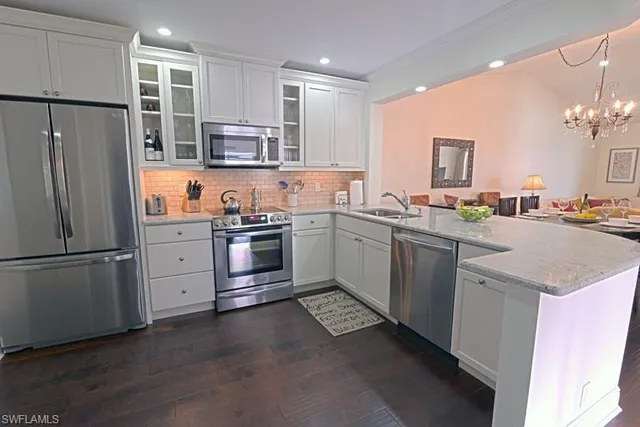 a kitchen with a sink stainless steel appliances and white cabinets