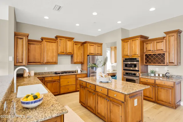 a kitchen with stainless steel appliances granite countertop a sink stove and cabinets