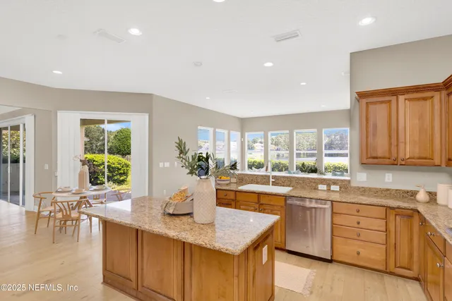 a large kitchen with stainless steel appliances granite countertop a lot of counter space and a sink