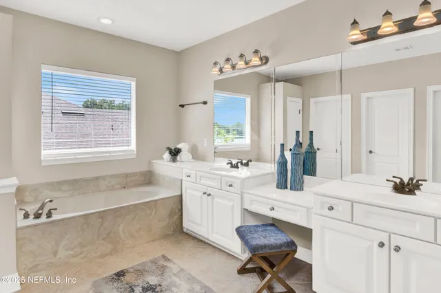 a spacious bathroom with a granite countertop tub sink and mirror
