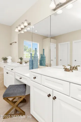 a bathroom with a sink a large mirror and a light fixture