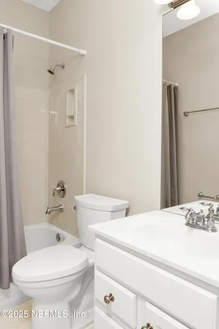 an empty room with ceiling fan and windows
