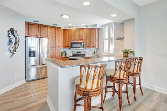 a kitchen with stainless steel appliances granite countertop a sink and a white cabinets
