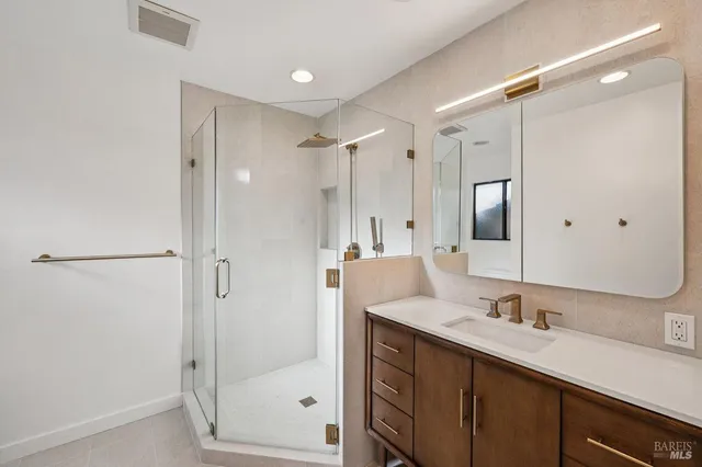 a bathroom with a double vanity sink mirror double and shower