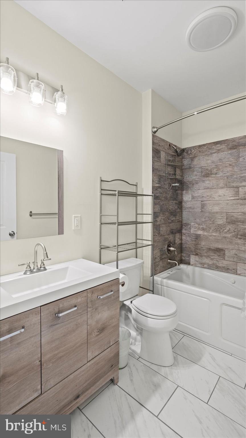 3145 Baybriar Road Dundalk, MD 21222 - Photo 44 of 54 a bathroom with a double vanity sink toilet and shower
