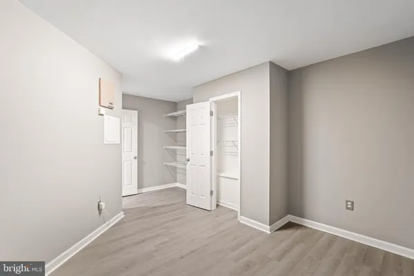 an empty room with closet and wooden floor