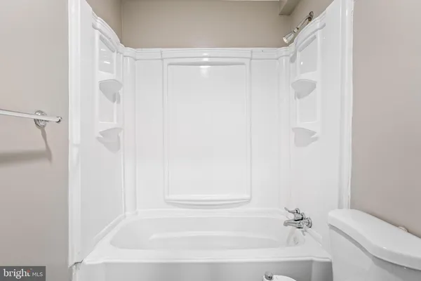 a bathroom with a bathtub shower sink vanity and toilet