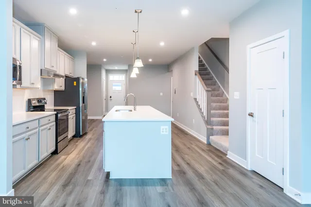 a kitchen with a sink stainless steel appliances and counter space