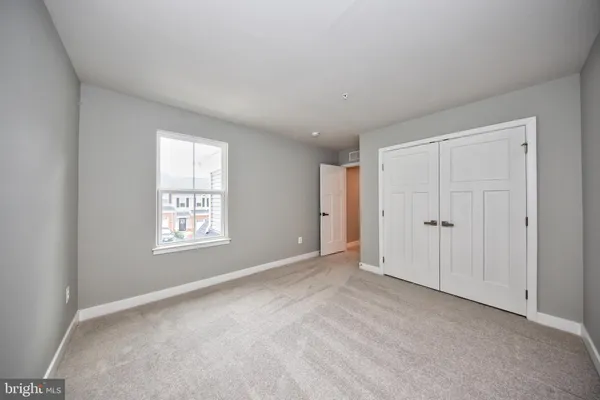 an empty room with windows and closet