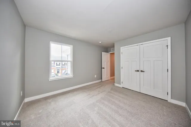 an empty room with windows and closet