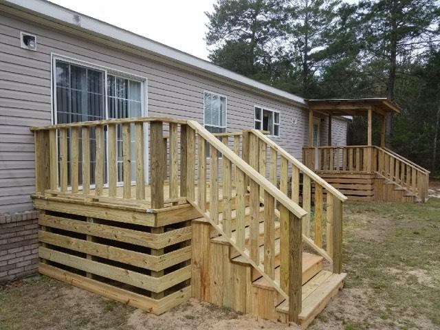 319 Delaware Road DeFuniak Springs, FL 32433 - Photo 18 of 22 a view of a house with wooden stairs and a floor to ceiling window
