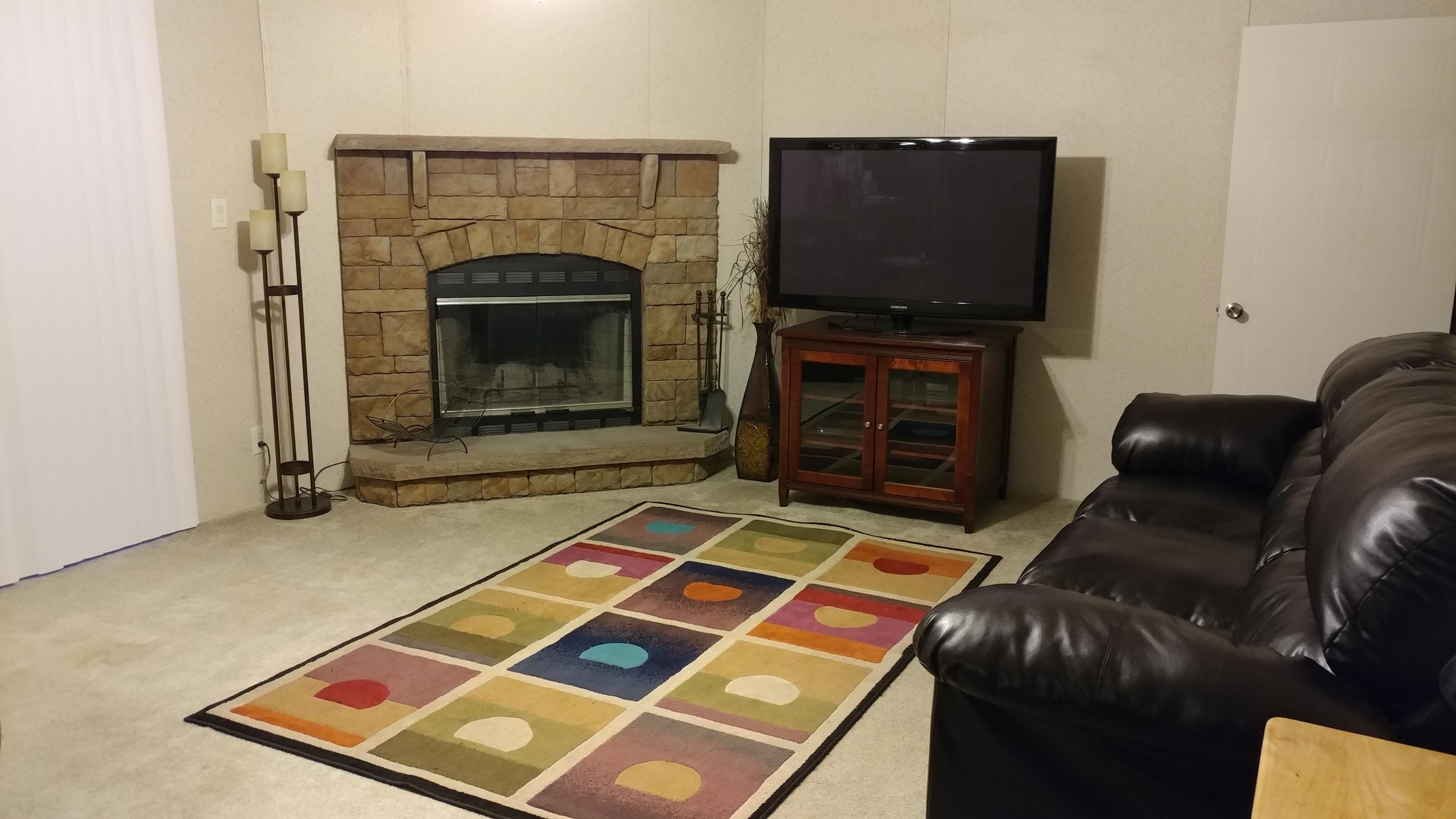 319 Delaware Road DeFuniak Springs, FL 32433 - Photo 3 of 22 a living room with furniture a flat screen tv and a fireplace