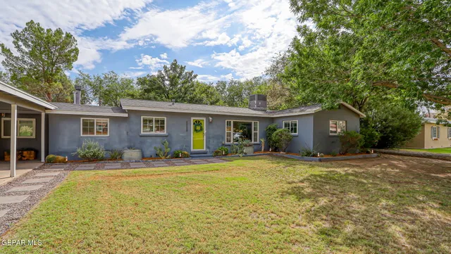 a front view of house with outdoor seating and green space