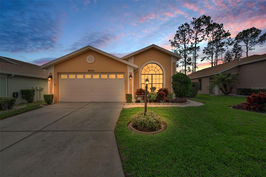 9630 Green Needle Drive New Port Richey, FL 34655 - Photo 82 of 83 a front view of a house with a garden