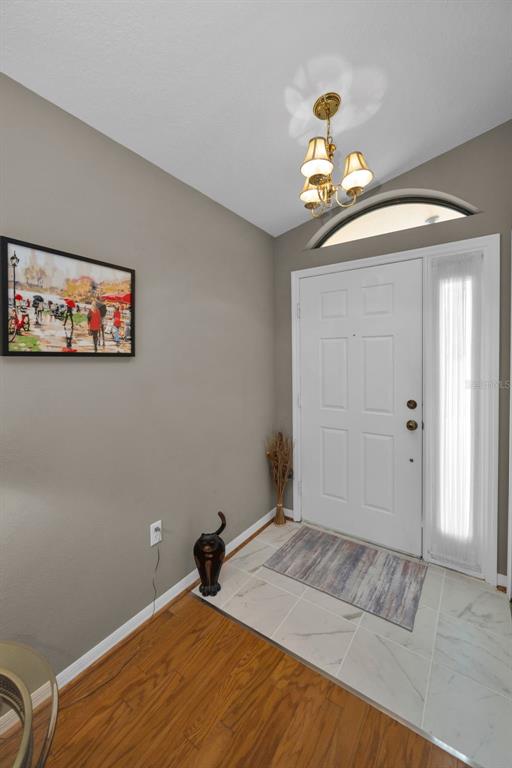 9630 Green Needle Drive New Port Richey, FL 34655 - Photo 10 of 83 a bedroom with a bed and a chandelier