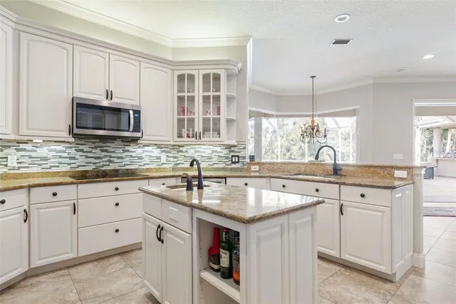 a dining room with furniture a chandelier and kitchen view