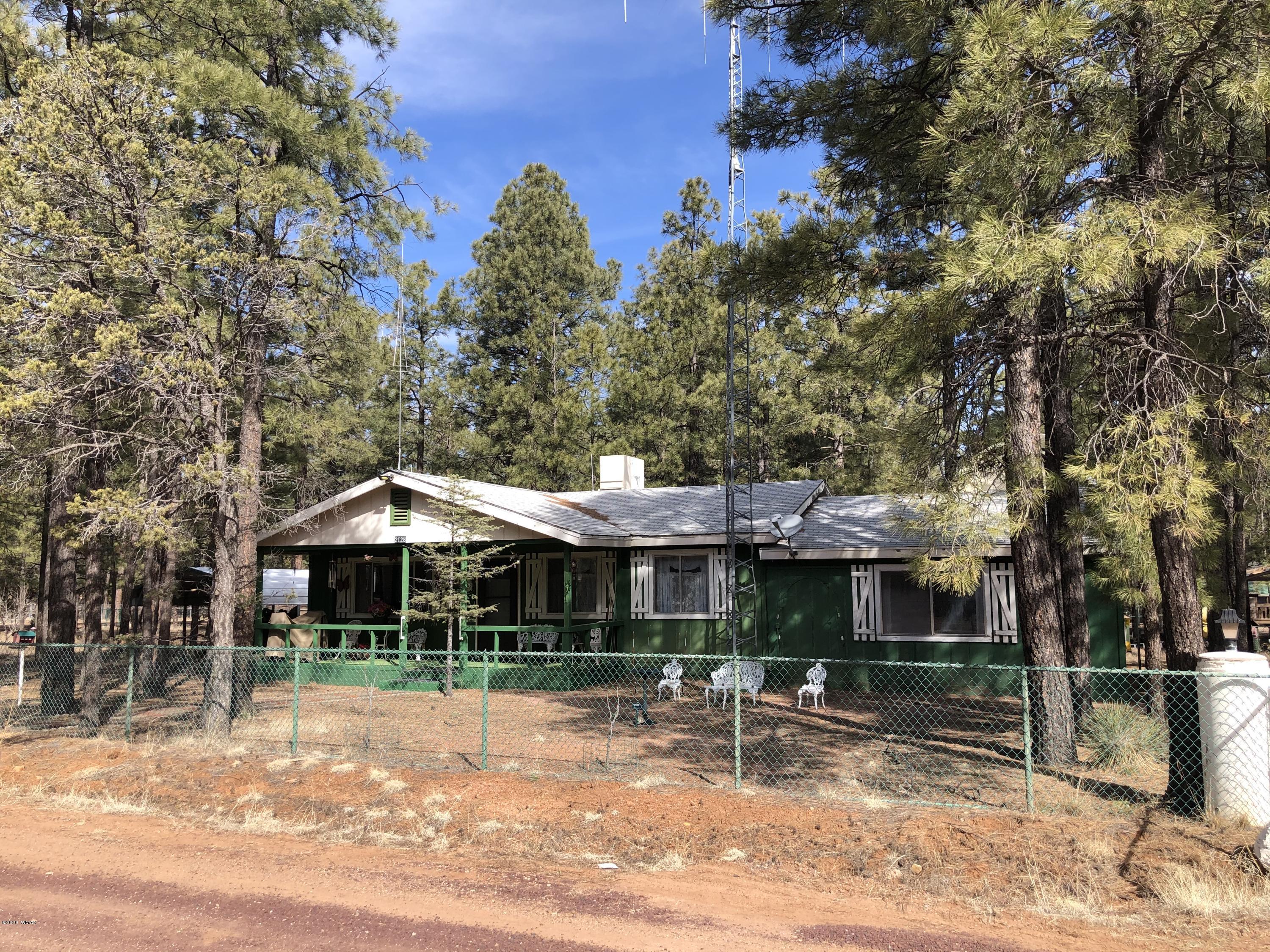 2128 Pony Road Overgaard, AZ 85933 - Photo 1 of 3 a front view of a house with garden