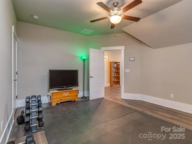 a view of room with workspace and a ceiling fan