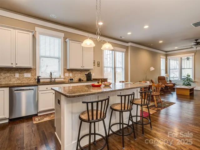a kitchen with a dining table chairs sink and white appliances