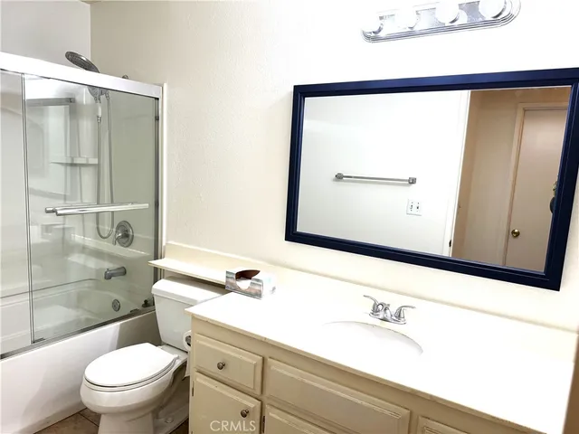 a bathroom with a granite countertop sink mirror vanity and toilet
