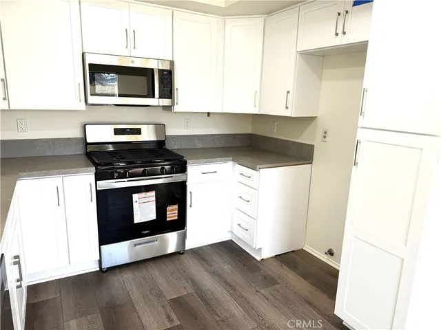 a kitchen with granite countertop wooden cabinets and stainless steel appliances