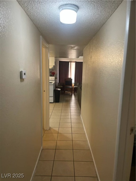 4150 Solteros Street, Unit 1 Las Vegas, NV 89103 - Photo 6 of 25 Corridor featuring light tile patterned flooring, a textured ceiling, and a textured wall