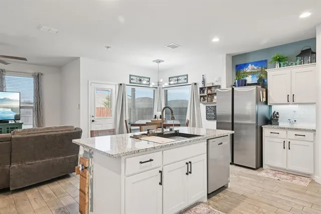 a kitchen with stainless steel appliances a refrigerator sink and stove