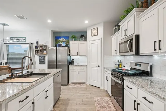 a kitchen with stainless steel appliances granite countertop a refrigerator sink and stove