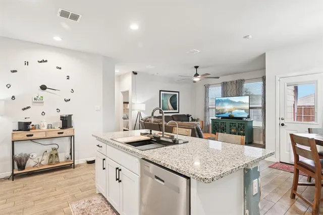 a kitchen with granite countertop a sink and cabinets
