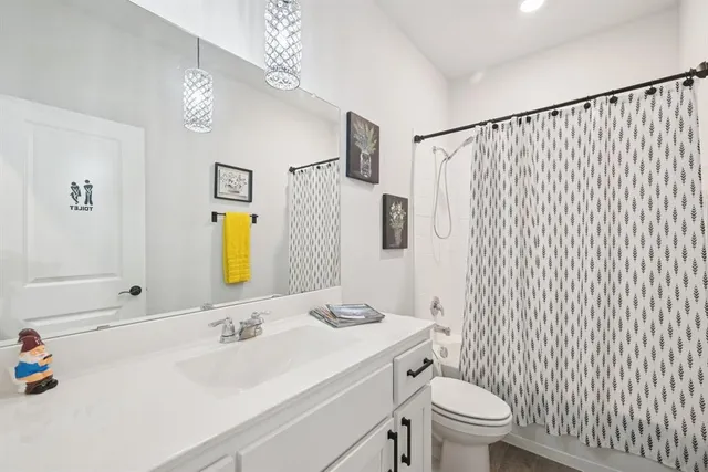 a bathroom with a sink vanity mirror and toilet