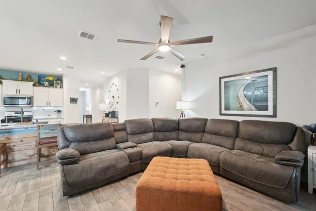 a living room with furniture and a view of kitchen