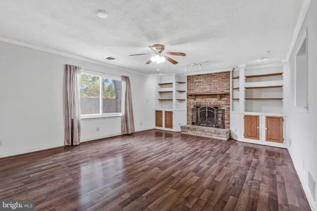 a view of empty room with a fireplace and wooden floor