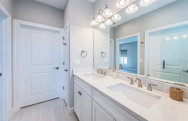 a spacious bathroom with a double vanity sink mirror and chandelier