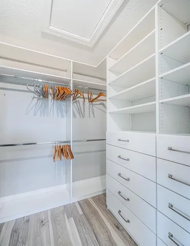 a view of walk in closet with clothes and shoes
