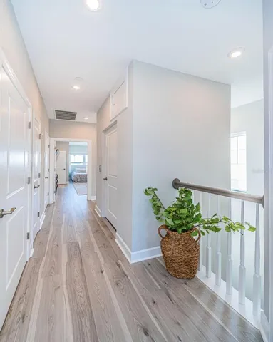 a room with wooden floor and lots of potted plants